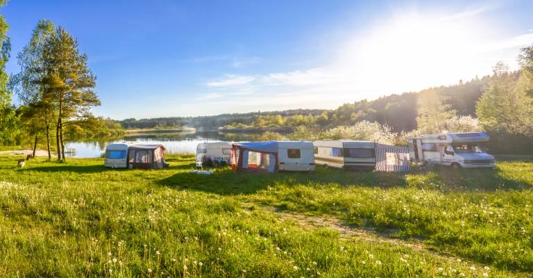 familie vakantie op een camping met caravans en campers rondom een meer