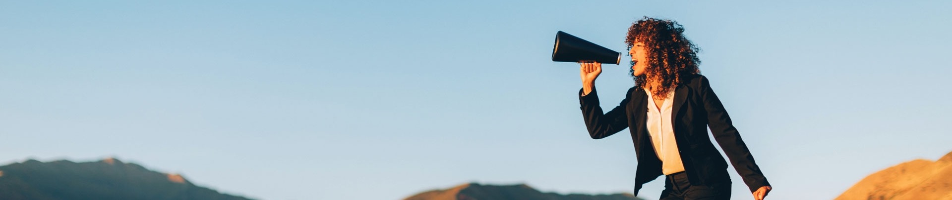 Zakenvrouw schreeuwt door een megaphone